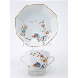 A Meissen octagonal two-handled cup and saucer painted with the quail pattern with chocolate rims...