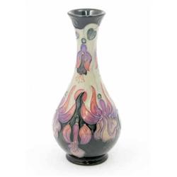 A Moorcroft Collectors Club Fuschia vase, decorated in shades of purple and pink against a two-to...