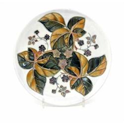 A Moorcroft Bramble Plate, late 1990's, decorated in shades of blue, pink and light brown against...