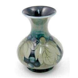 A Moorcroft leaf and berry vase, circa 1925, decorated in shades of green and blue against a gree...