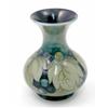 Image 1 : A Moorcroft leaf and berry vase, circa 1925, decorated in shades of green and blue against a gree...