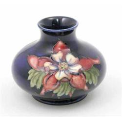 A Moorcroft Columbine squat vase, circa 1955, decorated in shades of red, green and yellow agains...