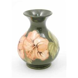 A Moorcroft coral Hibiscus vase, circa 1968-78, decorated in shades of green and coral against a...