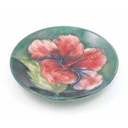 A Moorcroft Hibiscus pin dish, post war, decorated in shades of blue, green and pink against a gr...