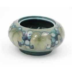 A Moorcroft Leaf and Berry bowl, circa 1925, decorated in shades of green and blue against a gree...