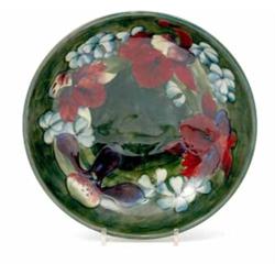 A Walter Moorcroft Orchid bowl, circa 1953-70, decorated in shades of red, green and blue against...