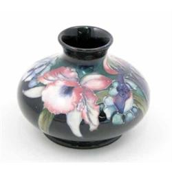 A Moorcroft Orchid squat vase, circa 1928-49, decorated in shades of blue, pink and green against...