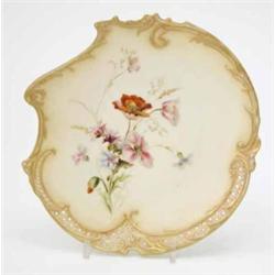 A Royal Worcester plate, of asymmetric shape pierced with diaper bands, moulded with c-scrolls an...