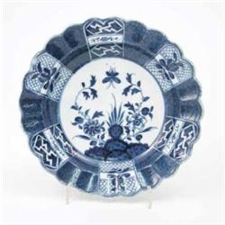A Caughley scalloped plate, painted with root flowers and a butterfly in underglaze blue, the ree...