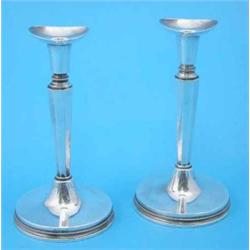 A pair of Swedish white metal candlesticks with tapered octagonal stems and loaded circular feet,...