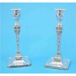 A pair of Edwardian silver Adam style candlesticks, with classical motif decoration and square fe...