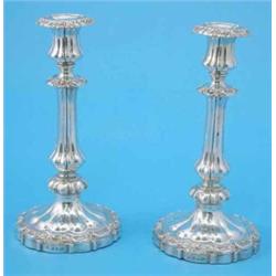A pair of William IV silver candlesticks, of knopped and fluted form with scroll and shell bandin...