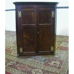 A MAHOGANY HANGING CORNER CUPBOARD, c.1800 two twin panelled front doors on brass H hinges openin...