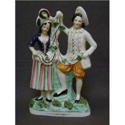 A STAFFORDSHIRE FIGURE GROUP, 19th Century, gentleman and female companion holding vine leaves, o...