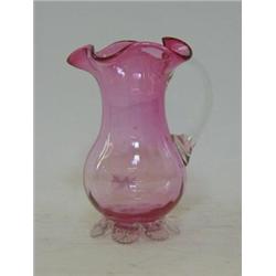 A RUBY GLASS JUG, wavy rim, clear loop handle, pincered foot rim, pontil base, height 14cm 30-40...