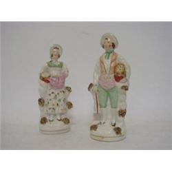 A PAIR OF STAFFORDSHIRE FIGURES, 19th Century, gentleman and lady gardeners, height 20cm, (lady's...