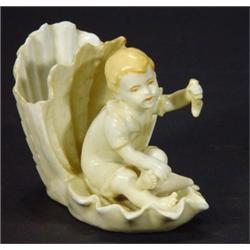 Continental seated porcelain boy in a shell…