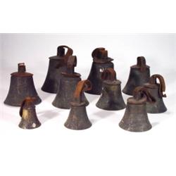 Nine bronze hand bells with leather straps,…