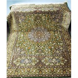 A Persian Qum silk rug. Signed in the border....