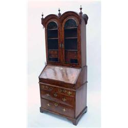 A good Queen Anne walnut bureau bookcase, feather-banded, having double-arched moulded cornice su...