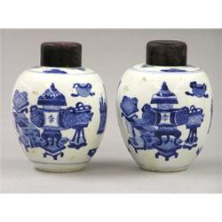 PAIR OF BLUE AND WHITE PORCELAIN JARS AND WOOD COVERS, Chinese. Kangxi Period. 1662-1722. Each...