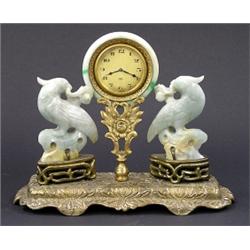 FINE BRASS AND CARVED PALE GREEN JADEITE DESK CLOCK, Swiss. Circa 1920. The circular dial with...