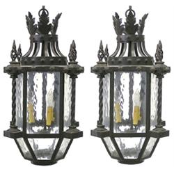 PAIR OF CAST IRON AND GLASS LANTERNS, Each with frosted glass panels and door below the pierced...