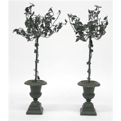 SET OF FOUR CAST METAL URNS, Each set with a topiary tree, raised on a stepped square base. Hei...