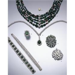 AN EMERALD AND DIAMOND CLUSTER RING CLAW SET TO THE CENTER WITH A RECTANGULAR CUT CORNERED