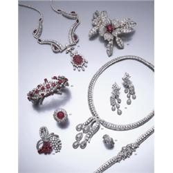 A RUBY AND DIAMOND BROOCH, CA. 1950 DESIGNED AS A CENTRAL FLOWER HEAD CLAW SET TO THE CENTE