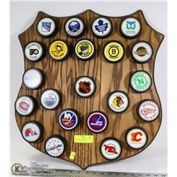 COLLECTION OF HOCKEY PUCKS ON WOOD TEXACO PLAQUE