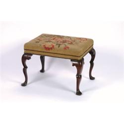 AN ANTIQUE WALNUT FRAMED FOOTSTOOL, in the early 18th century manner,, upholstered in needlewor...