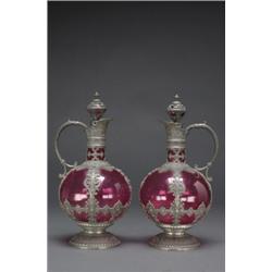 PAIR OF CONTINENTAL PEWTER MOUNTED RED GLASS CARAFES, of globular form with moulded scroll handle...