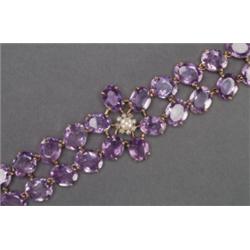 14K YELLOW GOLD BRACELET, set with 30 oval cut amethysts, with a central, medallion set with a...