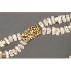 DOUBLE STRAND PEARL NECKLACE, composed of 119 flattened freshwater pearls and completed with a 14...