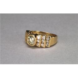 14K YELLOW GOLD RING, bezel set with an oval cut, diamond (approx. 0.80ct.) flanked by 18 brill...