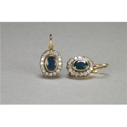 PAIR OF 14K YELLOW GOLD AND SILVER HOOK BACK EARRINGS, each bezel set with an oval cut sapphire (...