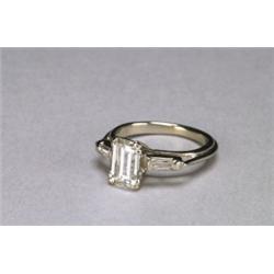 18K WHITE GOLD SOLITAIRE RING, set with an emerald cut diamond (approx. 1.27ct.) flanked by 2 sma...