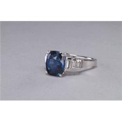 PLATINUM COCKTAIL RING, set with a fine oval cut sapphire (approx. 5.81ct.) flanked by 6 baguette...