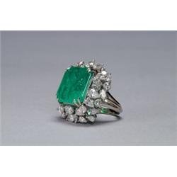 14K WHITE GOLD COCKTAIL RING, set with a large emerald cut emerald (approx. 18.75ct.) encircled b...