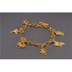 18K YELLOW GOLD CHARM BRACELET, with seven 18k, yellow gold charms depicting, animals and set...