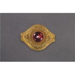 VICTORIAN 14K YELLOW GOLD BROOCH, formed as an ellipse bezel set with a circular garnet cabochon,...