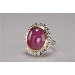 18K YELLOW AND WHITE GOLD COCKTAIL RING, bezel set with a large oval ruby cabochon (approx. 20.0c...