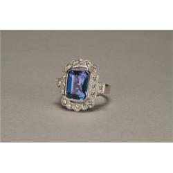 18K WHITE GOLD FILIGREE COCKTAIL RING, bezel set with a fine emerald cut tanzanite (approx. 4.75c...