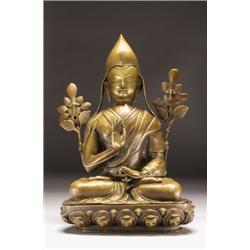 A BRONZE FIGURE OF TSONGKHAPA, seated on a lotus throne, his hands in, vitarkamudra, with flowe...