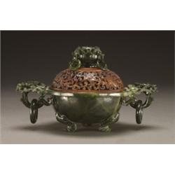 A FINE SERPENTINE INCENSE BURNER, the bowl with everted rim, worked with flowers, raised on three...