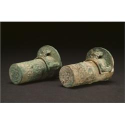 A PAIR OF ARCHAIC BRONZE AXLE CAPS AND PINS, the cylindrical bodies with low relief fretwork, the...