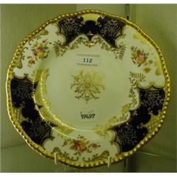 A Coalport Plate, with floral decoration and dark blue panels, within a gilt border