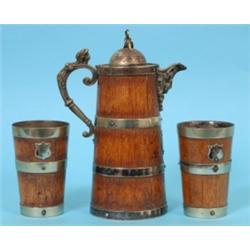 A Late Victorian Oak Jug, the plated mounts with face mask spout, and a pair of matching beakers (3)