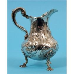 An 18th Century Style Silver Jug, decorated in relief with flowers and a vacant cartouche, on shell